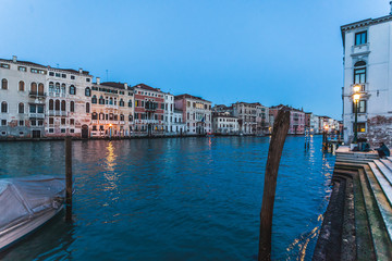 Typical Venetian canal with red houses at evening, Venice, Italy