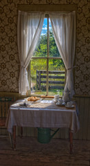 Turn of the century sitting table with view of fence through window