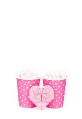 Latte with marshmallows in paper cups and pink heart. Two paper cups on white background. Copy space