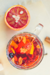 Tea made from dried fruit, seasoned with cinnamon cloves and anise seeds. There is an orange nearby