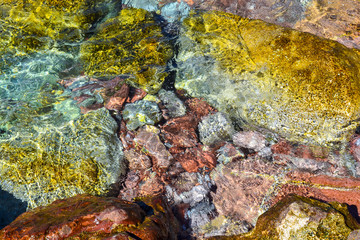 Fototapeta na wymiar Sea. Large coastal colorful stones in the water at the shore. Clear water. Adriatic Sea