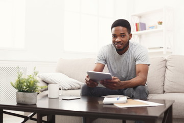 Young man at home messaging online on tablet