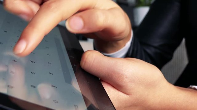 A Woman Types On A Tablet - Closeup From The Side