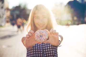 Smiling woman in summer holding donut
