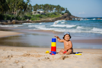 Fototapeta na wymiar Kid plays with toys at the seashore in summertime