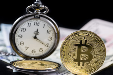 Golden bitcoin and pocket watch near on us dollars with black background