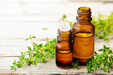 Thyme essential oil and fresh thyme on the wooden table