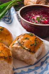 borscht with bread and onions on a wooden table