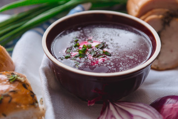 borscht with bread and onions on a wooden table