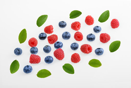 Raspberries and blueberries on white background.  top view