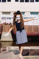 little mime girl shows pantomime on the street