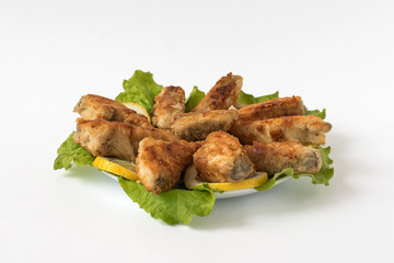 fried fish on a white plate with lettuce and lemon