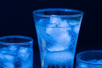Drink. Water glass and ice, dark background