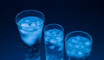 Drink. Water glass and ice, dark background