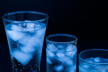 Drink. Water glass and ice, dark background