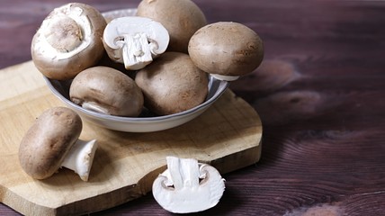 Mushrooms in a bowl on brown background