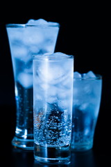 Drink. Water glass and ice, dark background