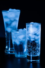 Drink. Water glass and ice, dark background