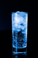 Drink. Water glass and ice, dark background