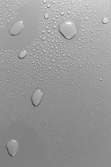 Surface with water drops, grey background.