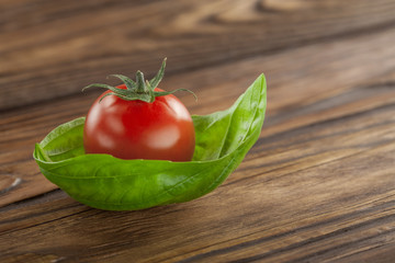 cherry tomato with basil on a wooden background