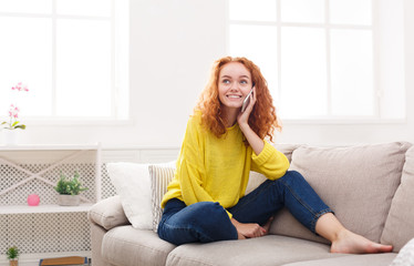 Happy girl making a call at home