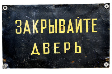 Old metallic door plate with a russian writing: Keep the door closed