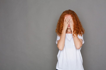 Young woman covering her face with hands