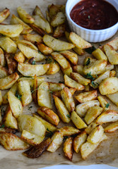 French fries in a paper basket on wooden table.