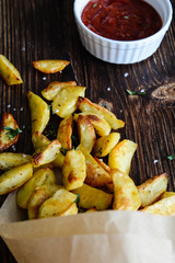 French fries in a paper basket on wooden table.