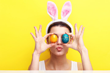 Happy young woman wearing bunny ears and having Easter Eggs