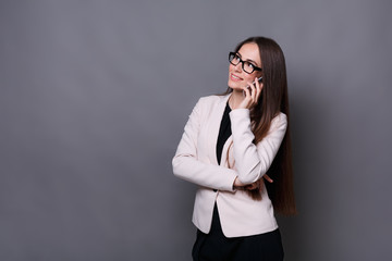 Happy brunette business lady talking on cell phone