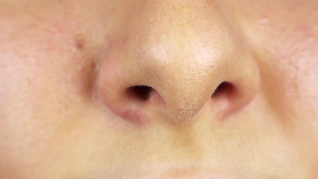 A woman squeezes her nose - closeup