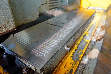 Magnetic plate on the grinding machine. Electric magnetic sine table.
