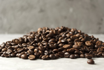 Bunch of coffee beans on dark grey background.