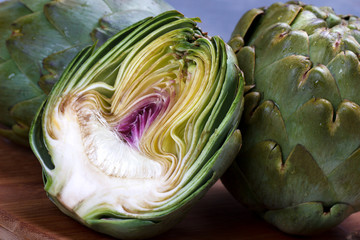 Obraz premium Close up of ripe organic artichokes on white wooden table, copy space