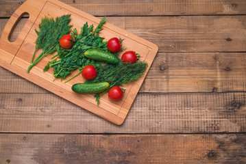 Dill, parsley, raw tomatoes and cucumbers on wooden table. Top view. Place for text