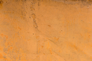 Textured background of a faded yellow paint with rusted cracks on rusted metal. Grunge texture of an old cracked metal surface. Rusty yellow-red stains