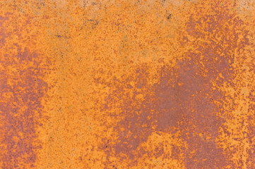 Textured background of a faded yellow paint with rusted cracks on rusted metal. Grunge texture of an old cracked metal surface. Rusty yellow-red stains
