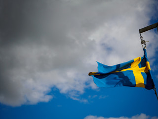 Swedish flag with gray clouds in the background
