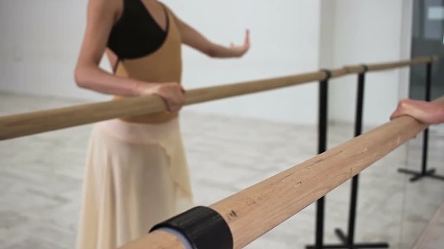 Beautifull ballerina posing at mirror, ballet barre. Atmosphere at ballet class.