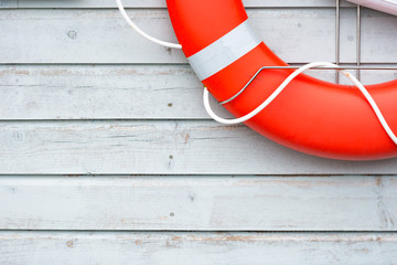 Orange lifebuoy on white wall in port