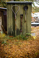 Green garden shed with fishing gear hanging on the wall