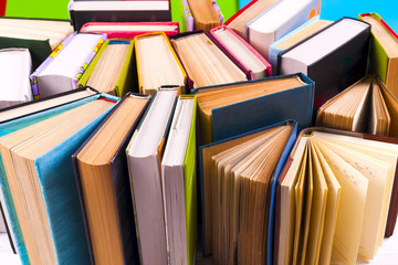 Open book, hardback books on bright colorful background.