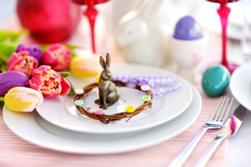 Beautiful table setting with crockery and flowers for Easter celebration