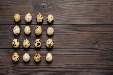 Quail eggs on dark wooden background. The view from the top. Copy spaсe