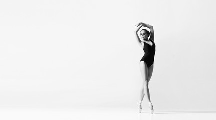 Graceful ballerina dancing in art performance. Young and beautiful ballet dancer in black and white.