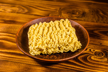 Ceramic plate with instant noodles on wooden table