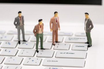 Small toy people are on the laptop , close up