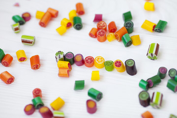 Colorful lollipops, candy canes and sweet candies mix on wooden background